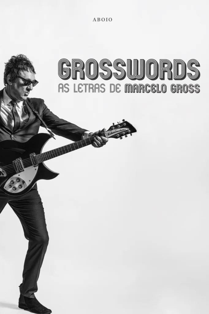 Capa do livro: "Grosswords - As letras de Marcelo Gross". Marcelo Gross está de pé, segurando uma guitarra em frente ao corpo.